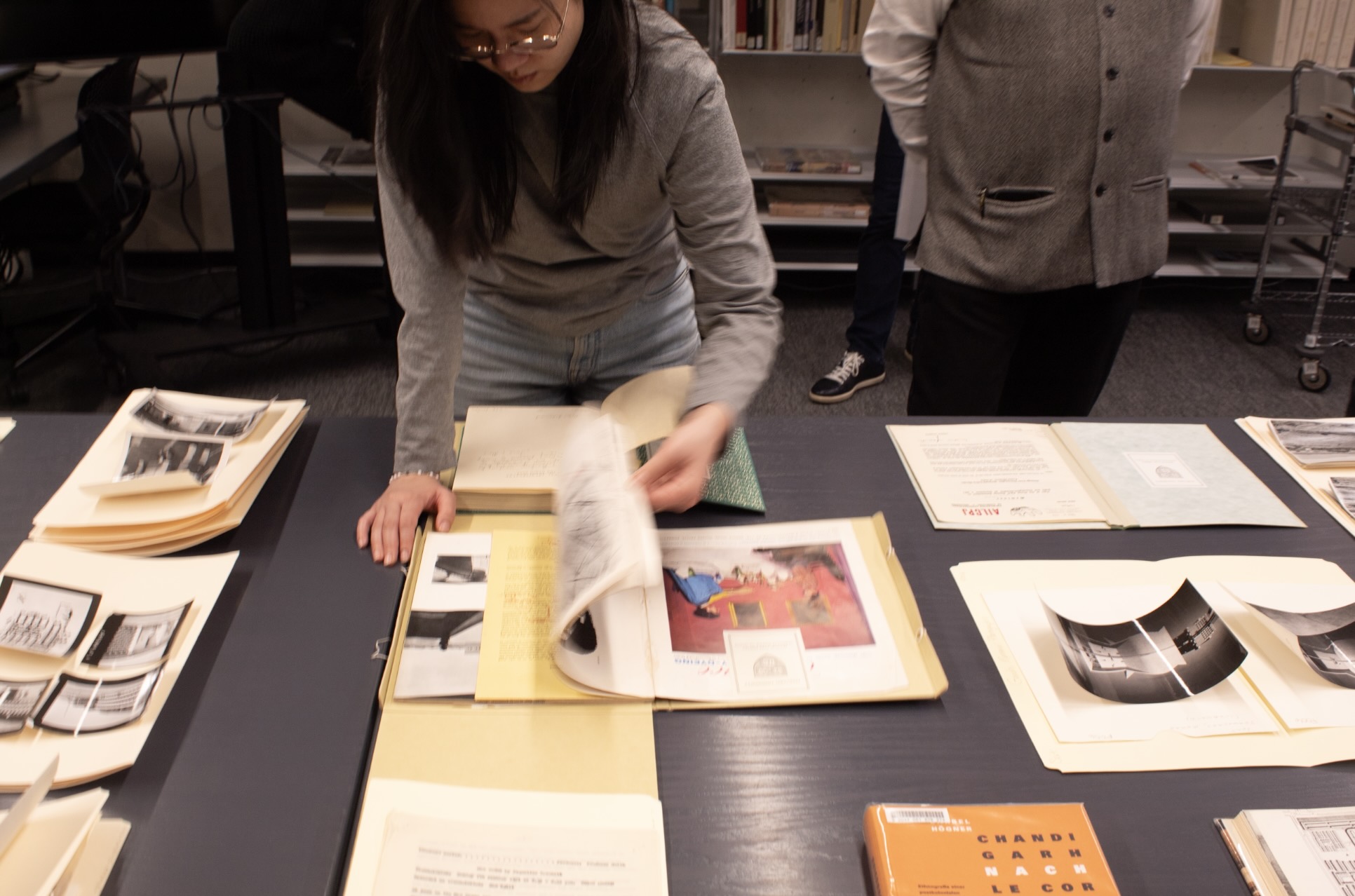 student flips through book on table